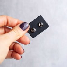 Silver minimalist steampunk earrings on card held in hand, 6mm